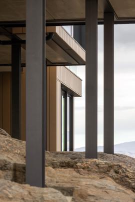 Steel frames rise out of the rock, encasing precast concrete slab floors.
