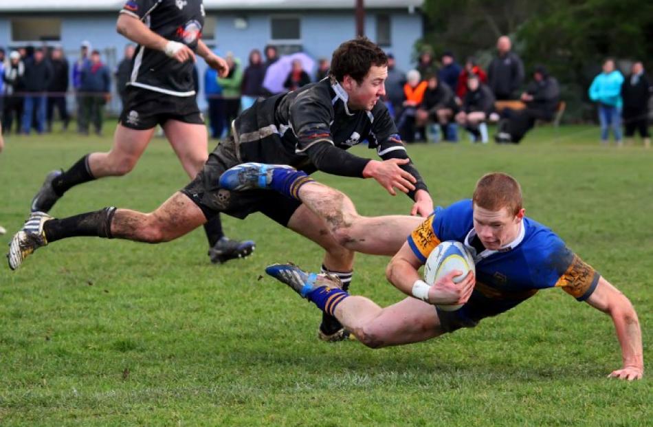 Winger Ben Miller dives to score one of Taieri's tries in the tackle of Pirates winger Scott...