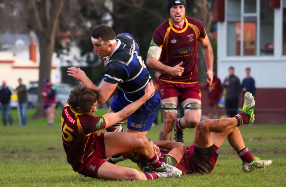 Kaikorai flanker Kyle Harris is dragged to the ground by Alhambra Union backs Noah Cooper and...