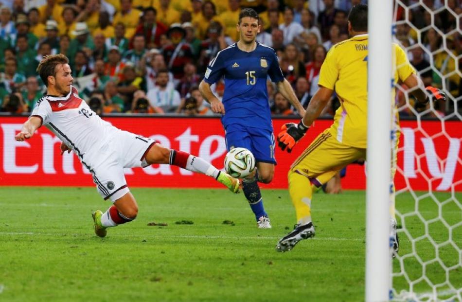 Goetze shoots to score past Argentina's goalkeeper Sergio Romero. REUTERS/Kai Pfaffenbach