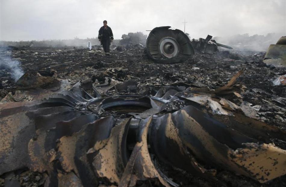 An Emergencies Ministry member inspects the site of a Malaysia Airlines Boeing 777 plane crash,...