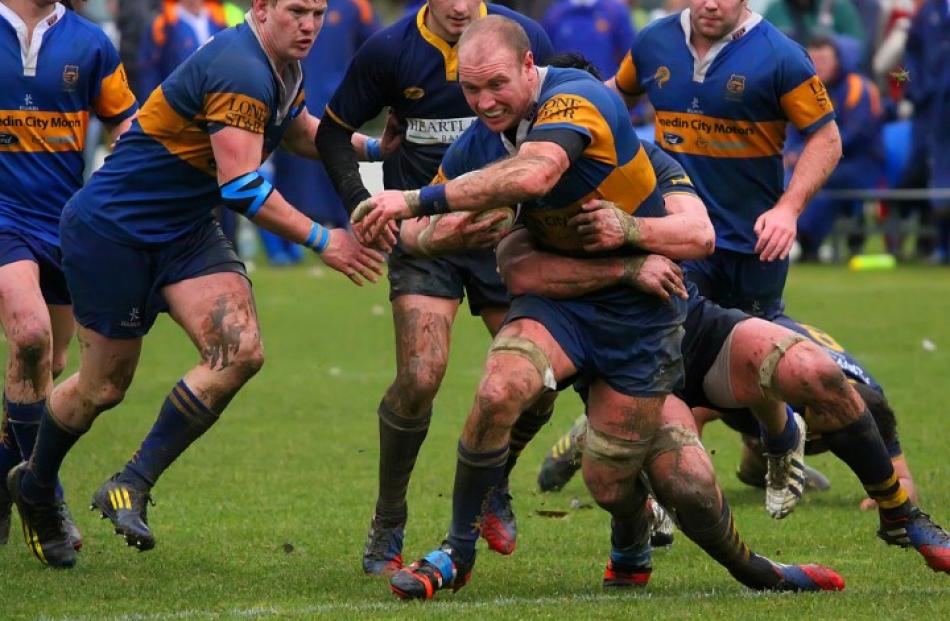 Taieri No 8 Charlie O'Connell attempts to break the tackle of Dunedin flanker Hugh Blake.