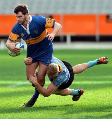 Taieri centre Kieran Moffat is tackled by University A lock Josh Dickson.