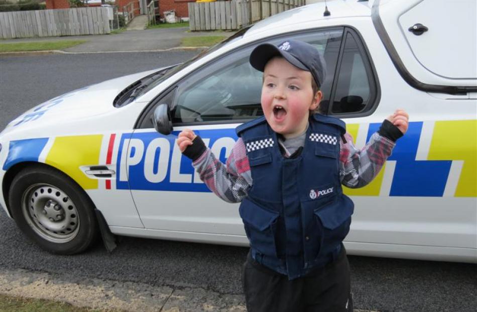 An excited Harley wears a police vest and cap.