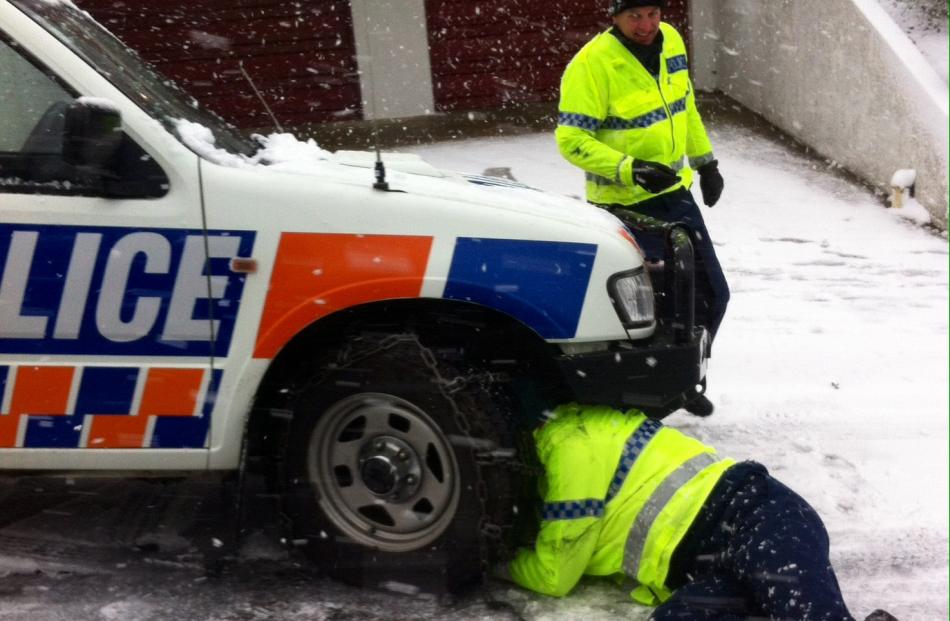 Police fit chains to their vehicle in Serpentine Ave.