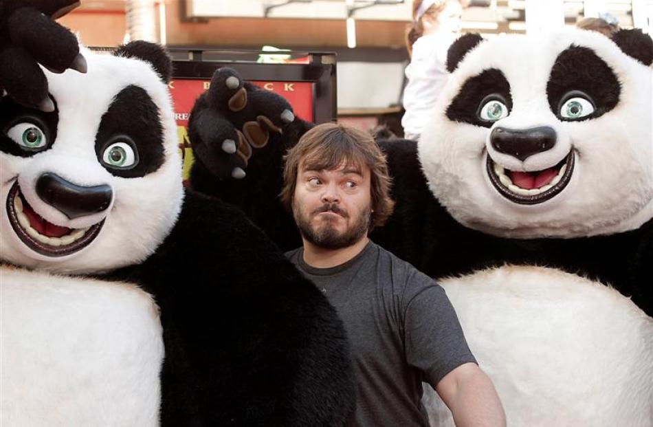 Actor Jack Black poses with two pandas. Photo Dan Steinberg/AP.