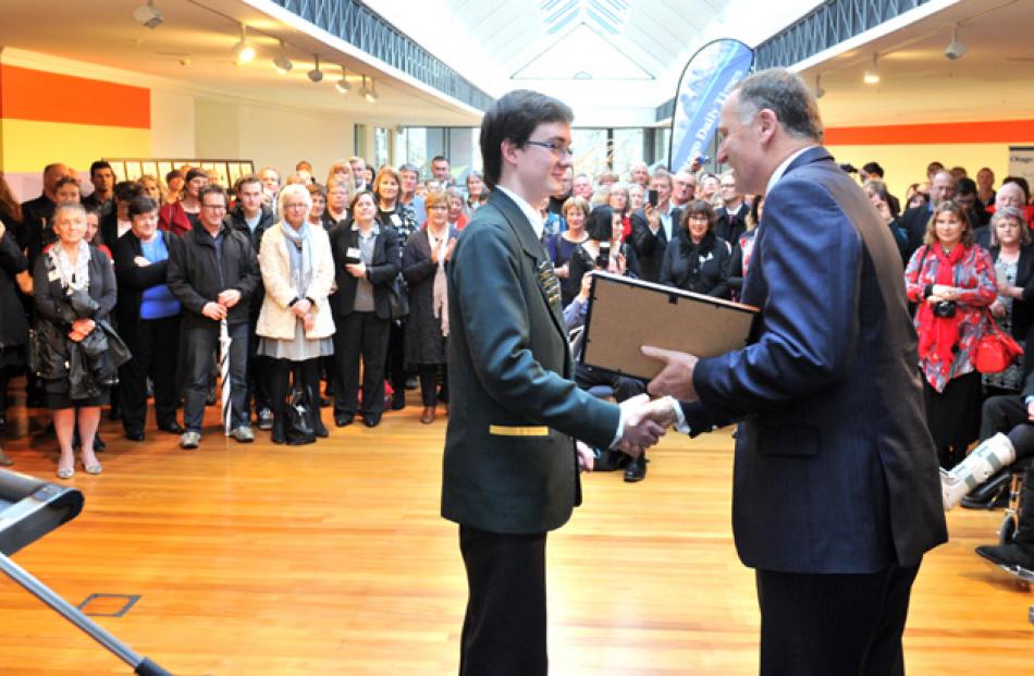 Elliot Tay of Bayfield High School receives his certificate from Prime minister John Key.