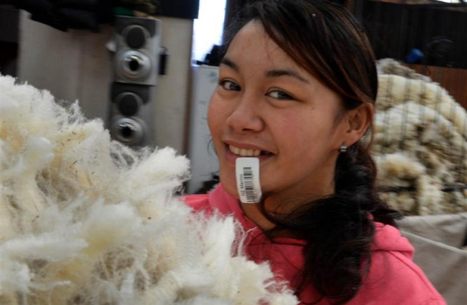 With both hands full of fleece, Anahera Williams uses some cunning to carry the accompanying...