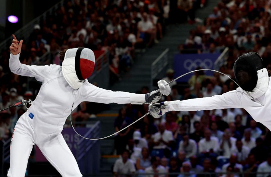 Martyna Swatowska-Wenglarczyk of Poland (left) and Sihan Yu of China compete in the women’s epee...
