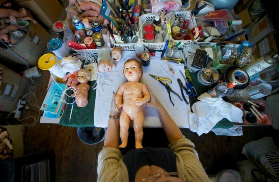 Kerry Stuart, a 25-year veteran at the hospital, repairs a doll on her workbench.