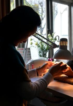 A Vietnamese migrant, who was working in underpaid and exploitative conditions, works on a client...