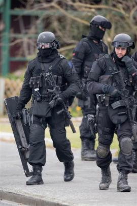 AOS members leave an Ashburton house they have just searched. Photo by NZ Herald.