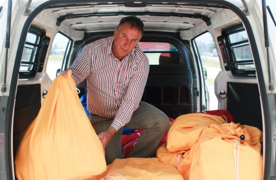 Murray Wilson loads fresh laundry into the  van.