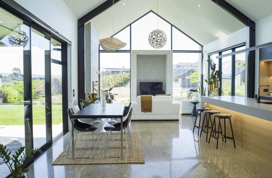 The main living area has a raked, tongue and groove ceiling and a polished concrete floor that...