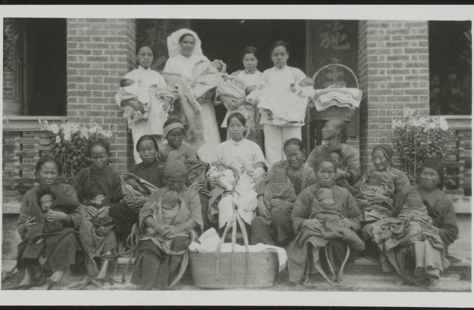 Sister Elizabeth Prentice with her Chinese nurses and village women who have brought their babies...