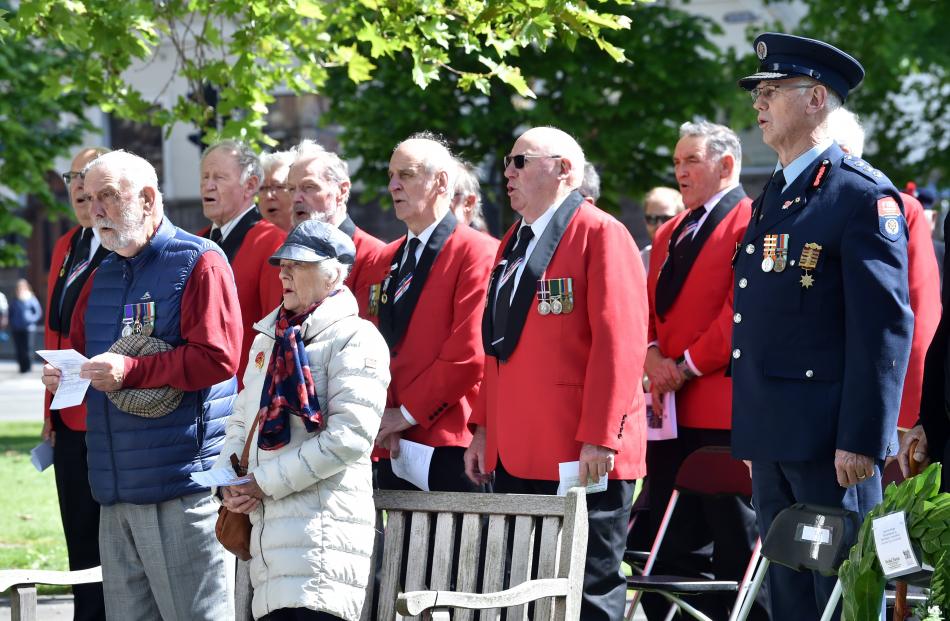 Armistice Day attendees and the RSA Male Choir sing during yesterday’s Dunedin service.