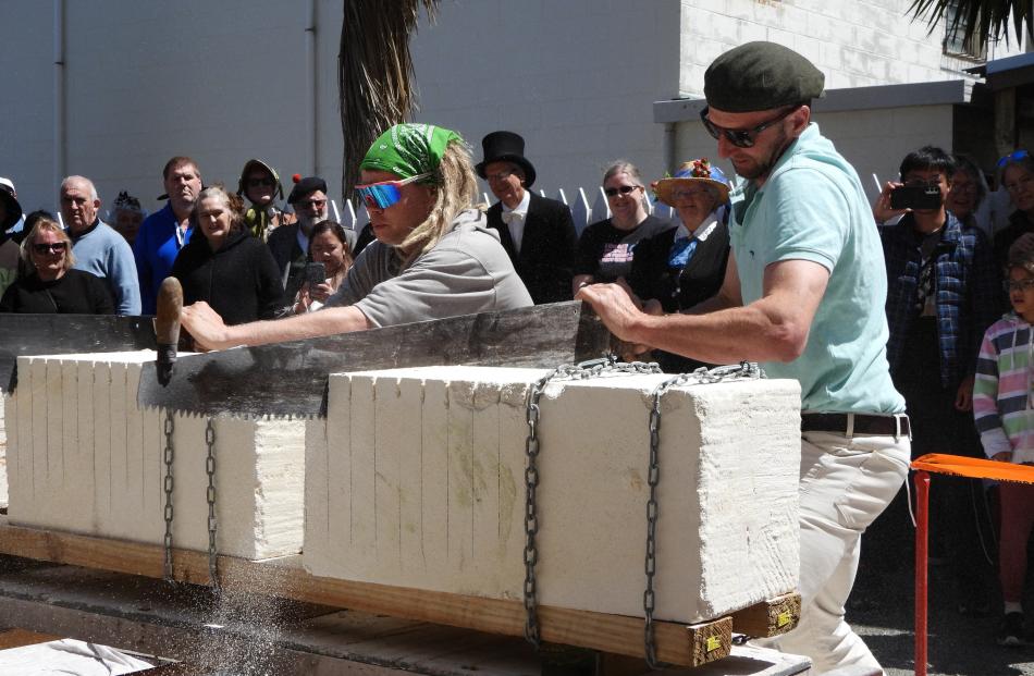 Dave Robertson (right), of Devils Creek, Oamaru, puts his all into the stone sawing during a heat...