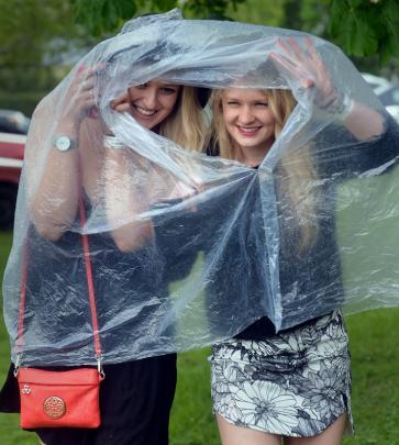 Plastic fantastic ... Bianca Becker (20) and Brittany Price (21) keep out the rain.