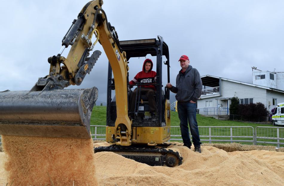 Boston Townsend, 11, of Stony Creek, operates a digger under the guidance of Snow Robertson, of...