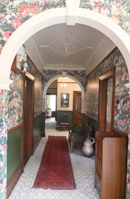 The entry hall features a tropical print above green-painted Analypta wallpaper. PHOTOS: LINDA...