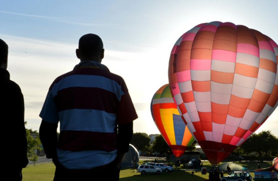 Spectators watch as colourful balloons are inflated in Oamaru's  Awamoa Park yesterday morning...