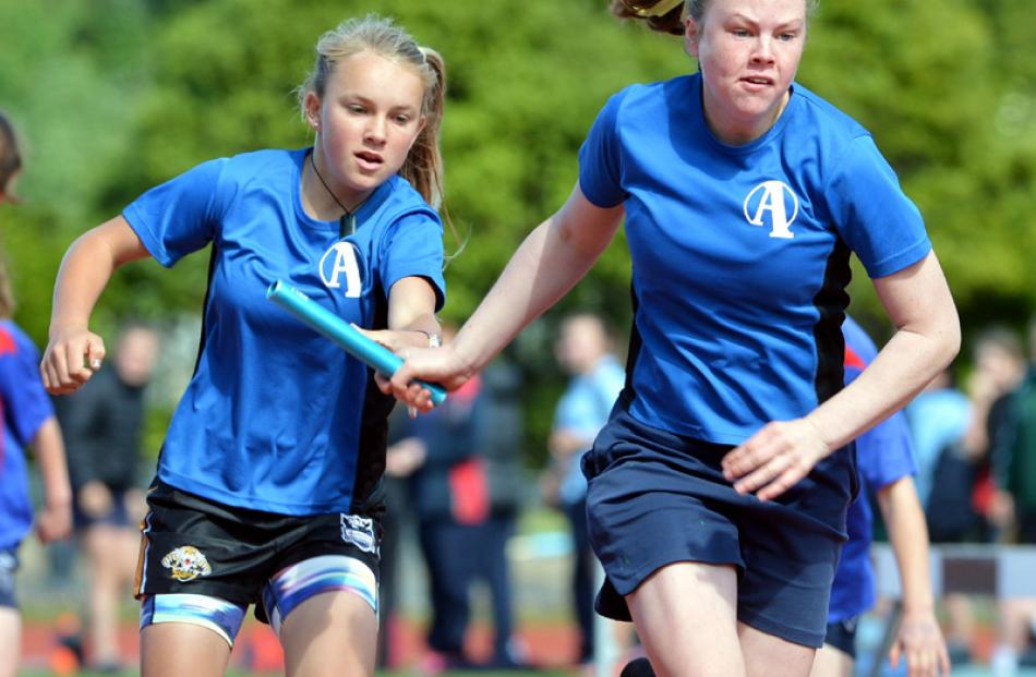 Maisie Bond (13) takes the baton from Keeli Cormack (13), Alexandra primary school, during the...