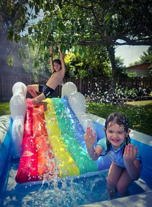 Waterslide fun ... Kahu Houpapa, 8, and Nevaeh Houpapa, 4, slide into 2025 at home in Ranfurly on...