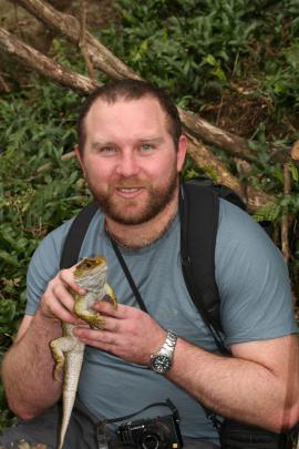 Scott Jarvie displays an adult tuatara. Photo by Allison Cree