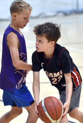 With ball in hand, Harry Bruce, 10, fakes to the right side of Fergus Kindiak, 9, as he eyes up...