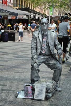 Entertainers, such as this living silver statue, add life to Brisbane's bustling Queen St Mall,...