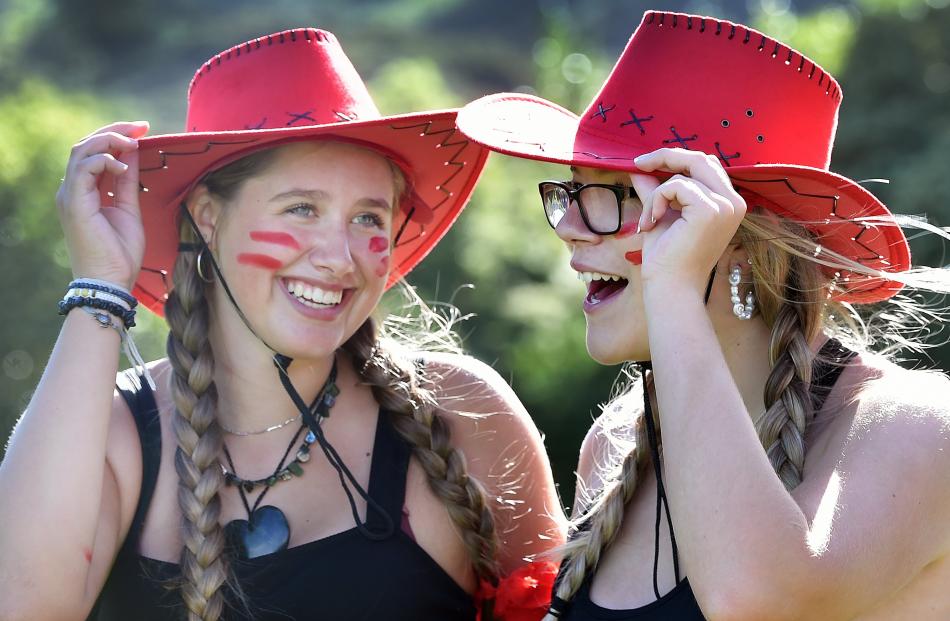 Maia Hamilton (left) and Sophie Campbell, both 16, tip their hats to fellow students during the...