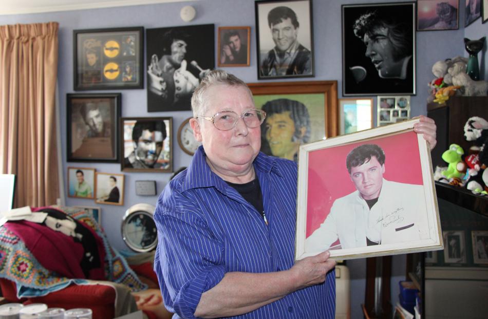 Denise Caley (64) holds a prized photograph of Elvis, the first one she had framed.  Photo by...