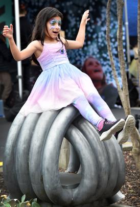 Charlotte Rama Nathan, 7, of Dunedin, plays on a street sculpture.