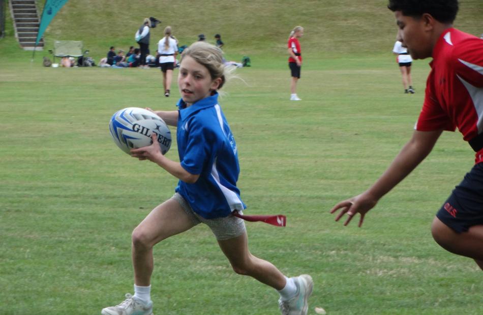 Kakanui School pupil Fleur Anderson, 9, tries to evade the Oamaru Intermediate School defender....