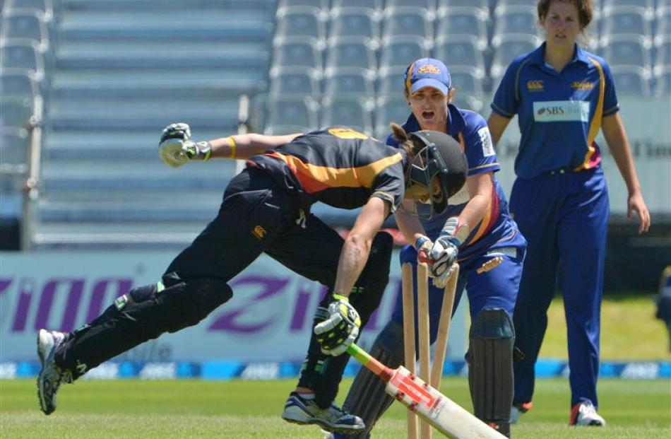 Wellington's Erin Burns squeaks home as Otago wicketkeeper Katey Martin dislodges the bails....
