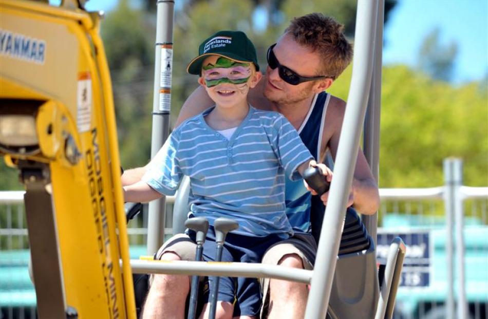 Jordan Genever takes control of a mini mechanical excavator, helped by dad Rhys, at the Otago...