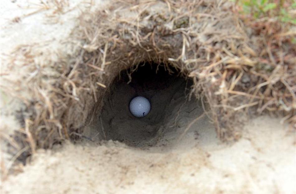 A golf ball down a hole.