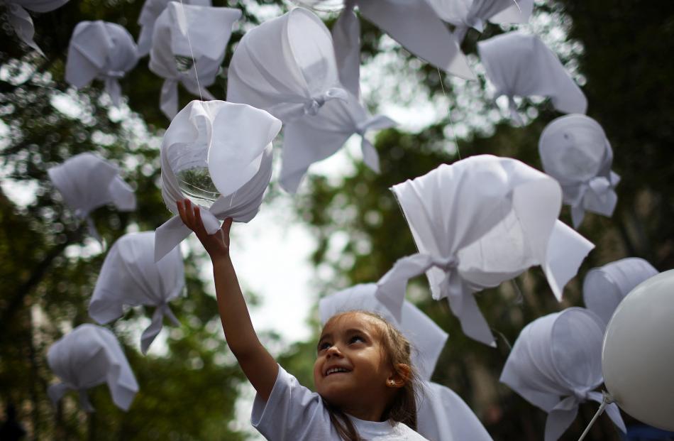 A child touches a white handkerchief, which symbolises struggle and resistance, during a...