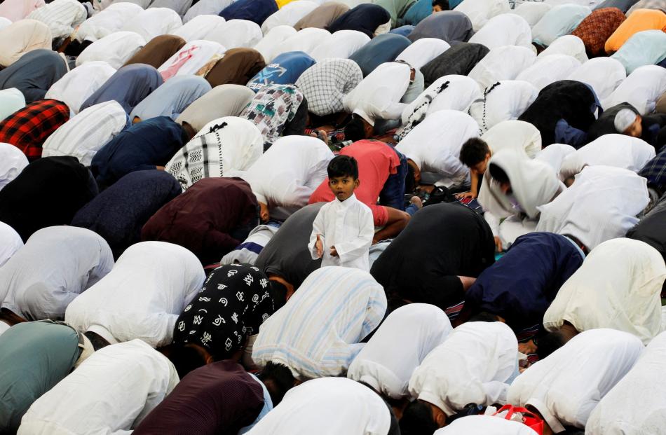 A child looks on as Muslim worshippers attend Eid al-Fitr prayer marking the end of the holy...