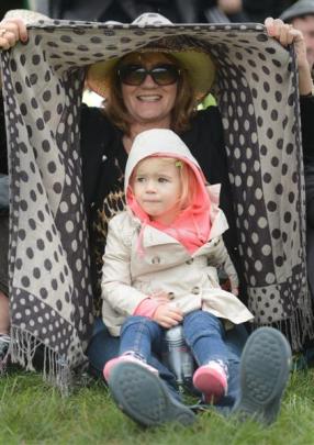 Lorraine Ward and Farah Smith (2), of Auckland, shelter from the rain.