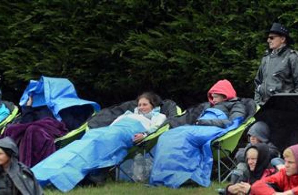 The crowd seeks cover from the rain at Outram Rodeo yesterday.