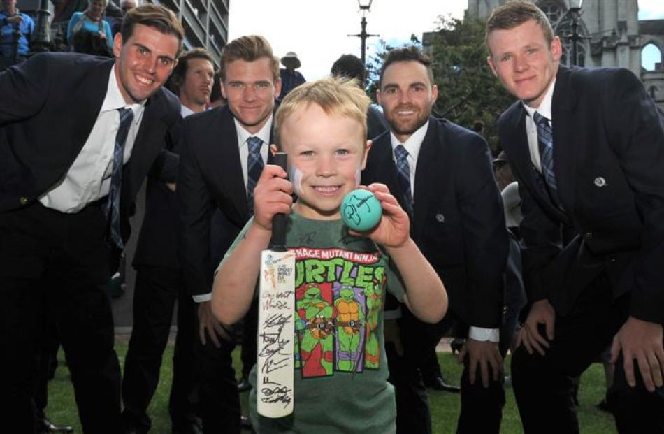 Riley Honings shows off his autographs with members of the Scotland cricket team (left to right)...