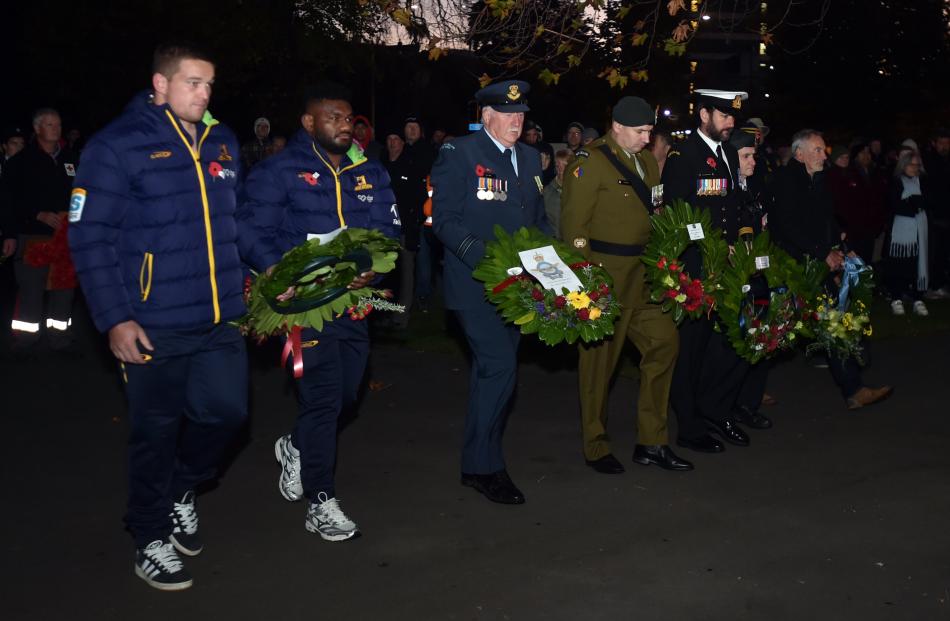 Members of the Highlanders and military bring forward their wreaths.