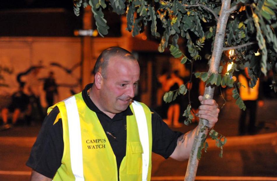 Campus Watch team member Simon Dixon tends to a vandalised tree in Castle St.