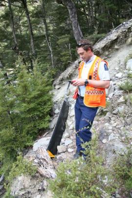 Constable Dan Andrew, of the Queenstown Police search and rescue squad, marks the position of a...