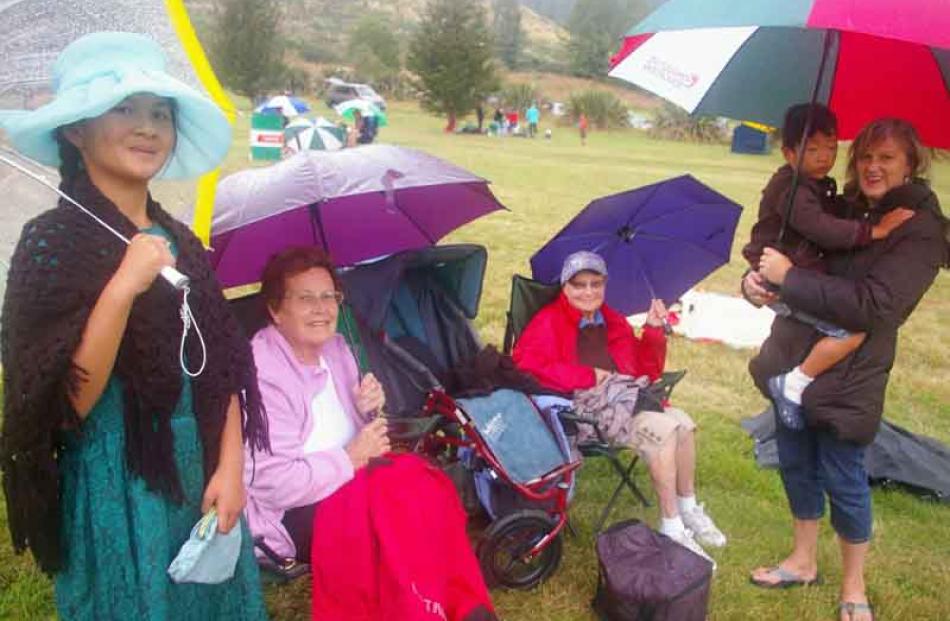 Brollies were fashionable accessories at Black Gully on Saturday. Annalei Symmons (10), of...