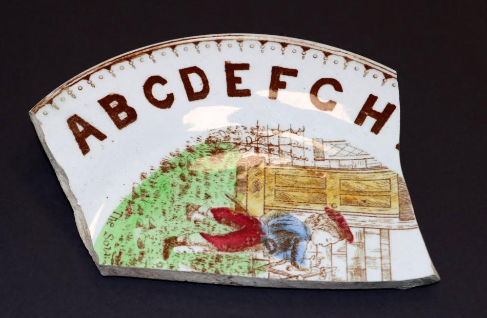 A piece of a broken plate with the alphabet around its circumference would have been used to help...