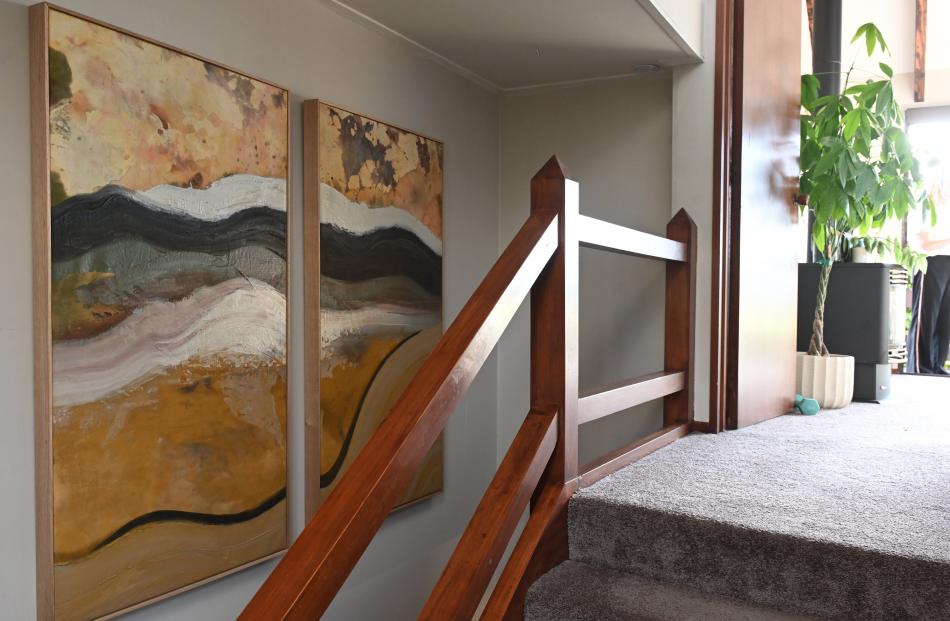 Ms Gallagher’s landscapes hang on one side of the stairwell...