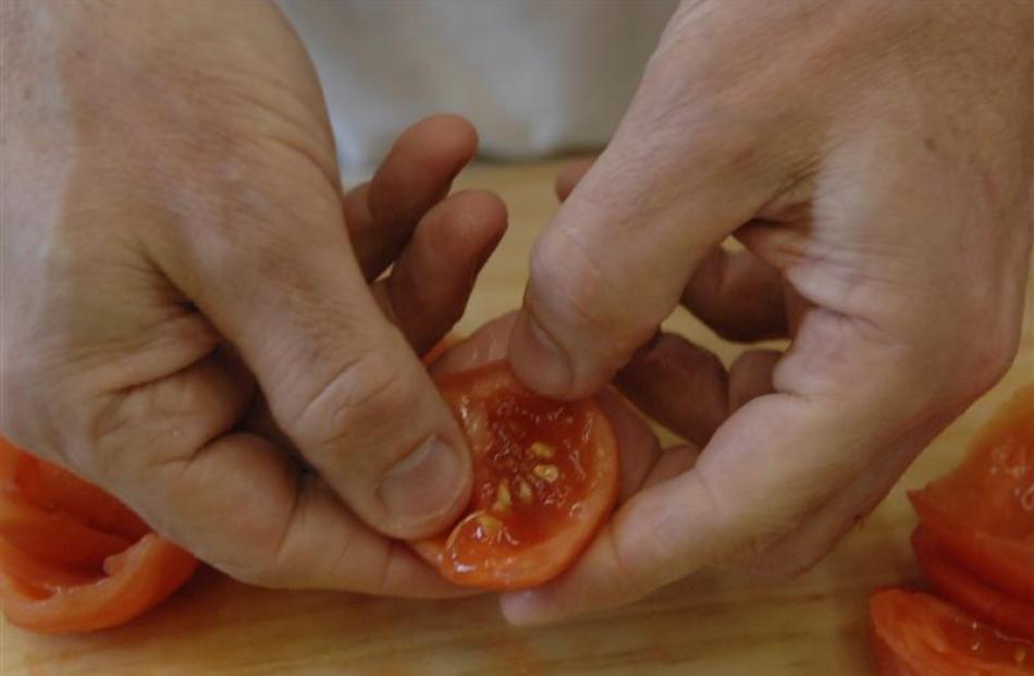 To make tomato topping, cut the sides of the tomato down like petals, take out the seeds and chop...
