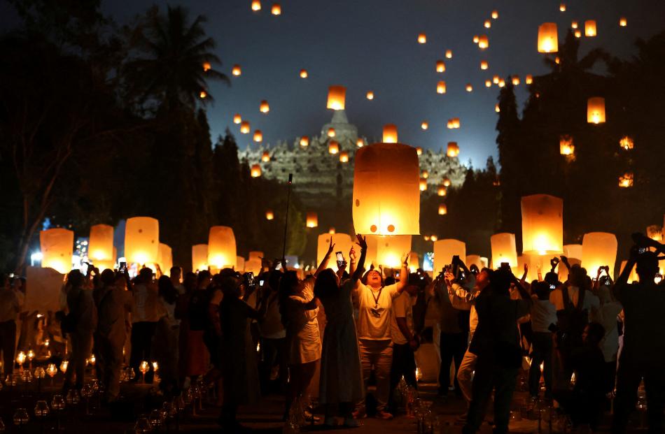 People release paper lanterns during a ceremony on Vesak Day, an annual celebration of the Buddha...